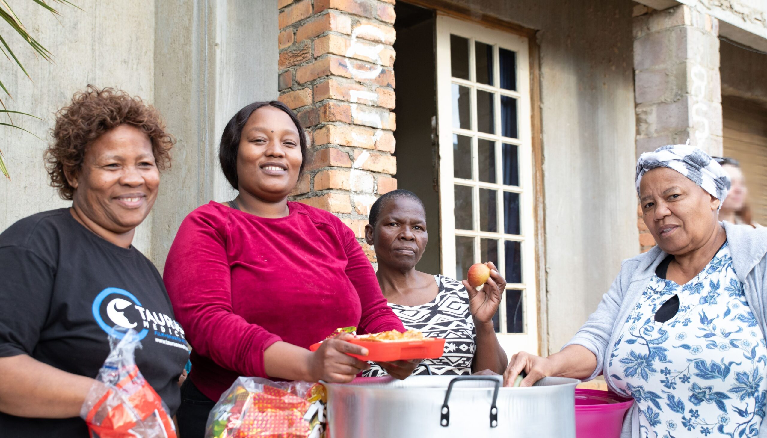 Image of the ladies from There is Life Here serving food for the children of Kayamandi